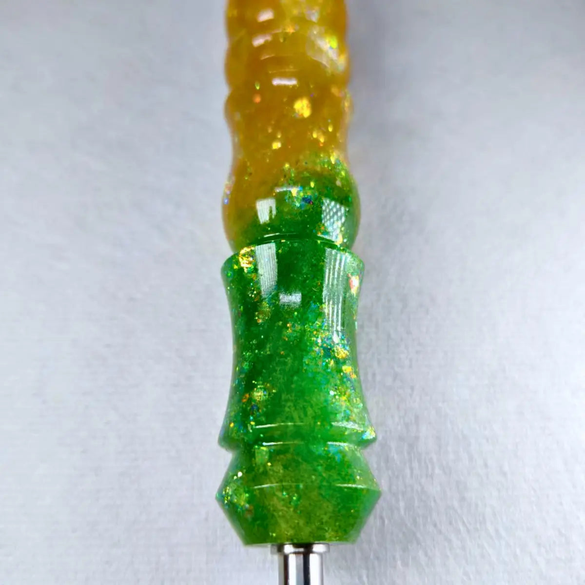 Nahaufnahme des handgefertigten Stifts mit grün-goldenem Farbverlauf