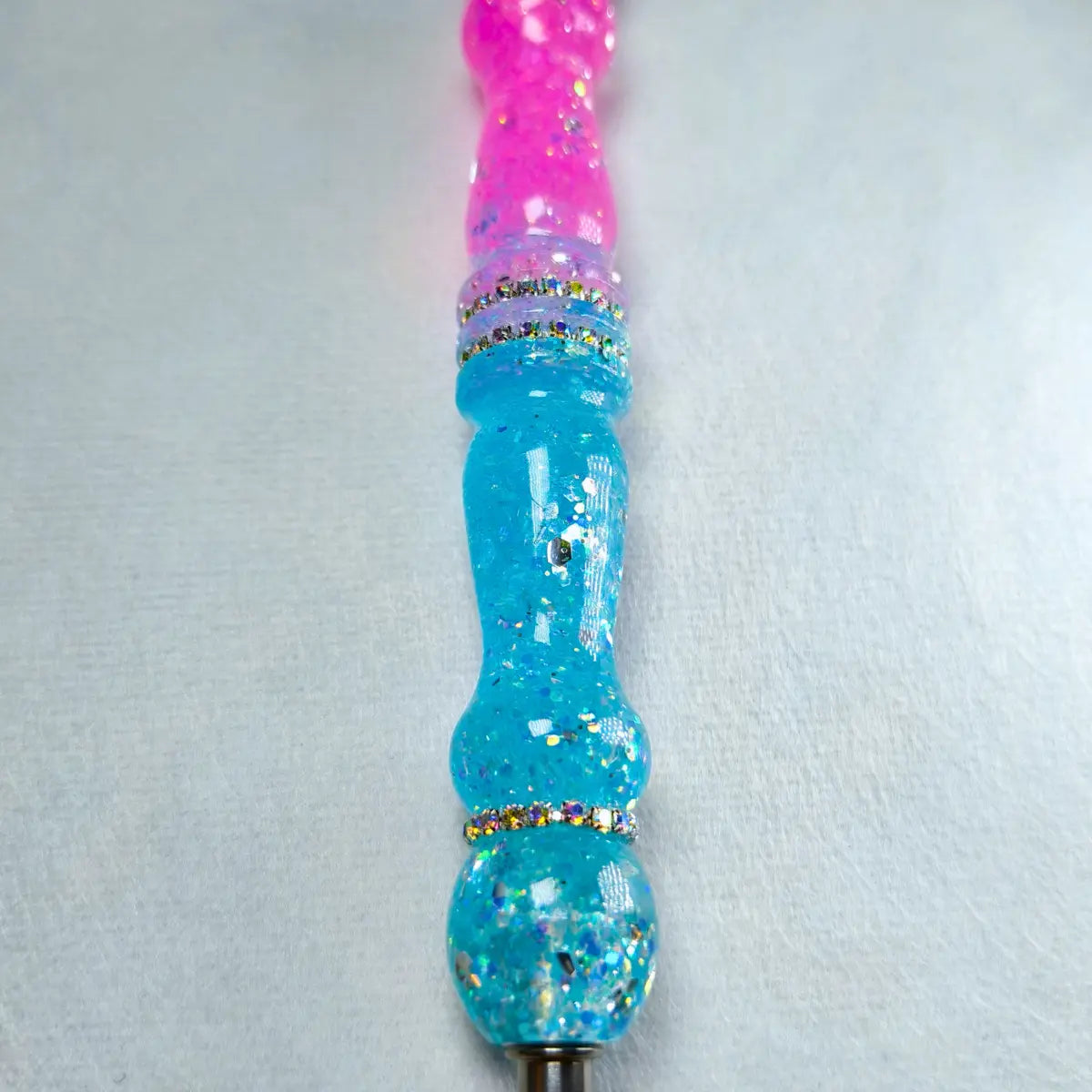Detail der pink-blauen Glitzereffekte des handgefertigten Stifts