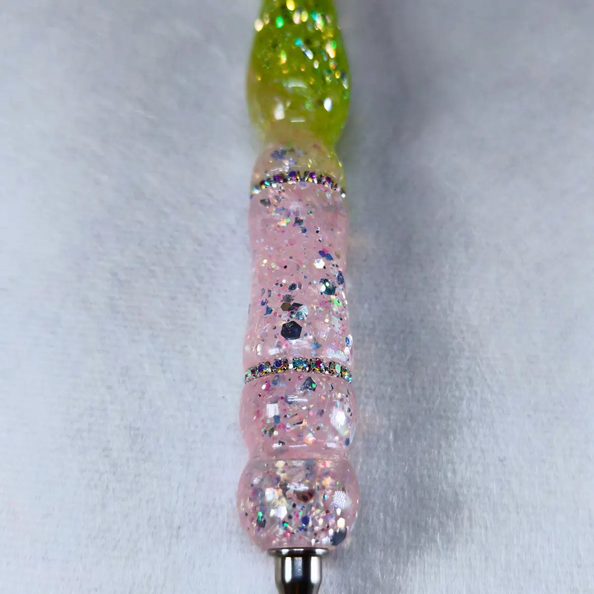 Detail der rosa-grünen Glitzereffekte des handgefertigten Stifts