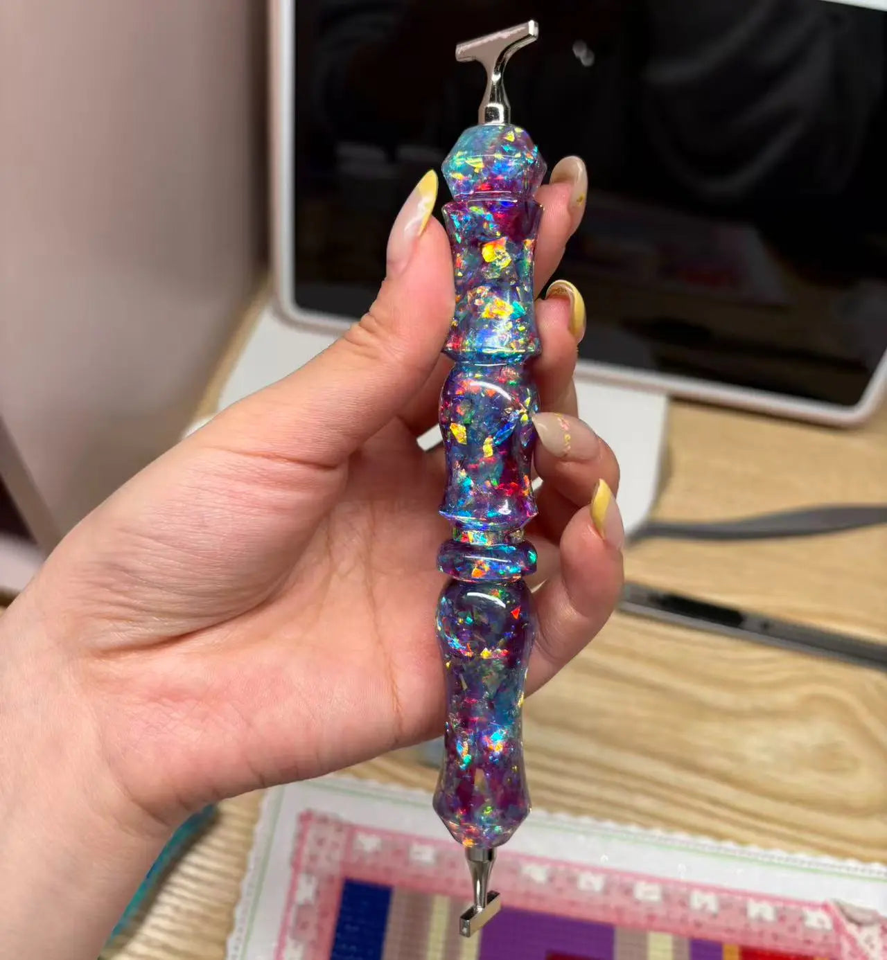 Foto eines Diamant-Stifts im Sternenhimmel-Stil mit glänzenden lila und blauen Pailletten, ideal für deine Diamond Painting-Projekte.