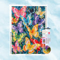 5D Diamond Painting Set mit einem Schwarm farbenfroher Schmetterlinge auf blauem Hintergrund.