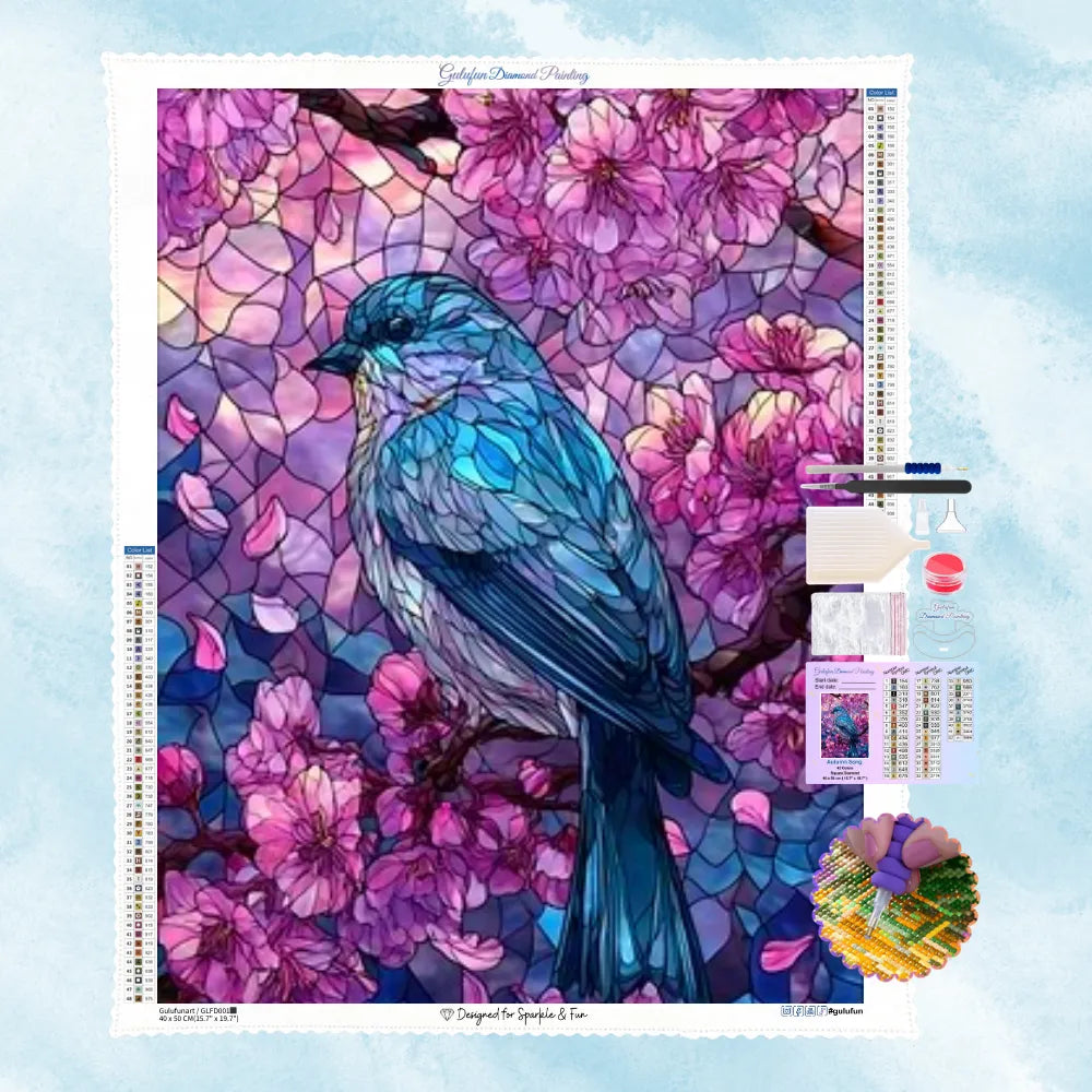 5D Diamond Painting Motiv: Ein leuchtend blauer Vogel auf einem Kirschblütenzweig, gestaltet im farbenfrohen Buntglas- und Mosaik-Stil.