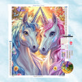 5D Diamond Painting Motiv: Zwei wunderschöne Einhörner mit blauer und rosafarbener Mähne, die ihre Hörner berühren, umgeben von Schmetterlingen und Blumen im Sonnenlicht.